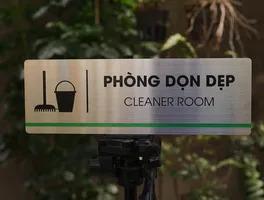 Phối cảnh thực tế bảng tên phòng dọn dẹp inox 304 brushed đặt trên tripod ngoài trời
