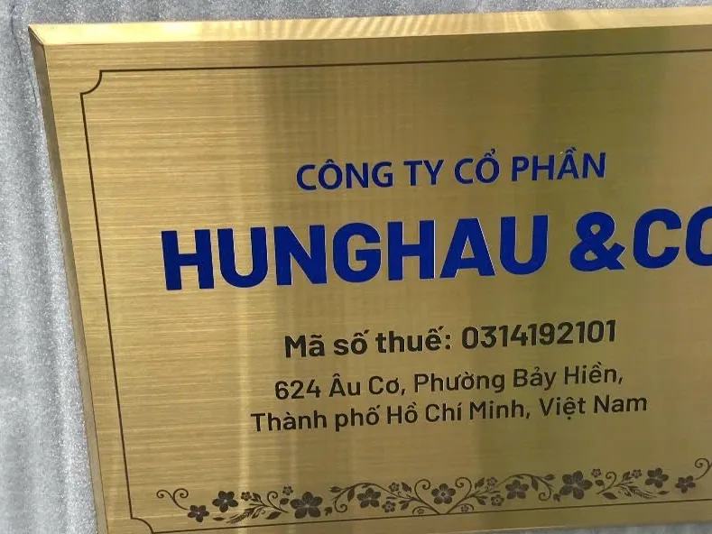 Làm Bảng Hiệu Công Ty Tại TPHCM Inox Vàng Xước Họa Tiết Làm bảng hiệu công ty tại TPHCM bằng inox vàng xước, in UV chữ xanh navy phối họa tiết hoa văn góc cổ điển