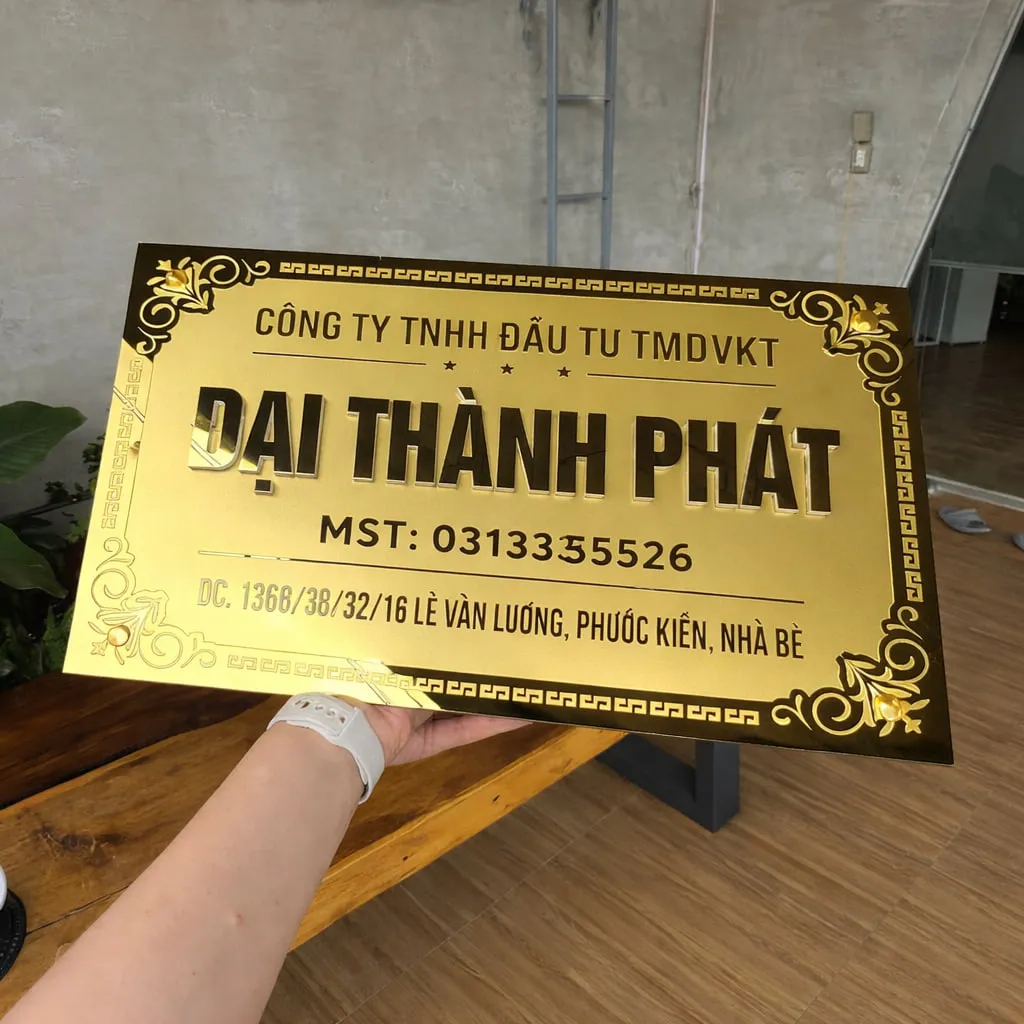 bảng hiệu công ty inox vàng gương phản chiếu ánh sáng tự nhiên sang trọng