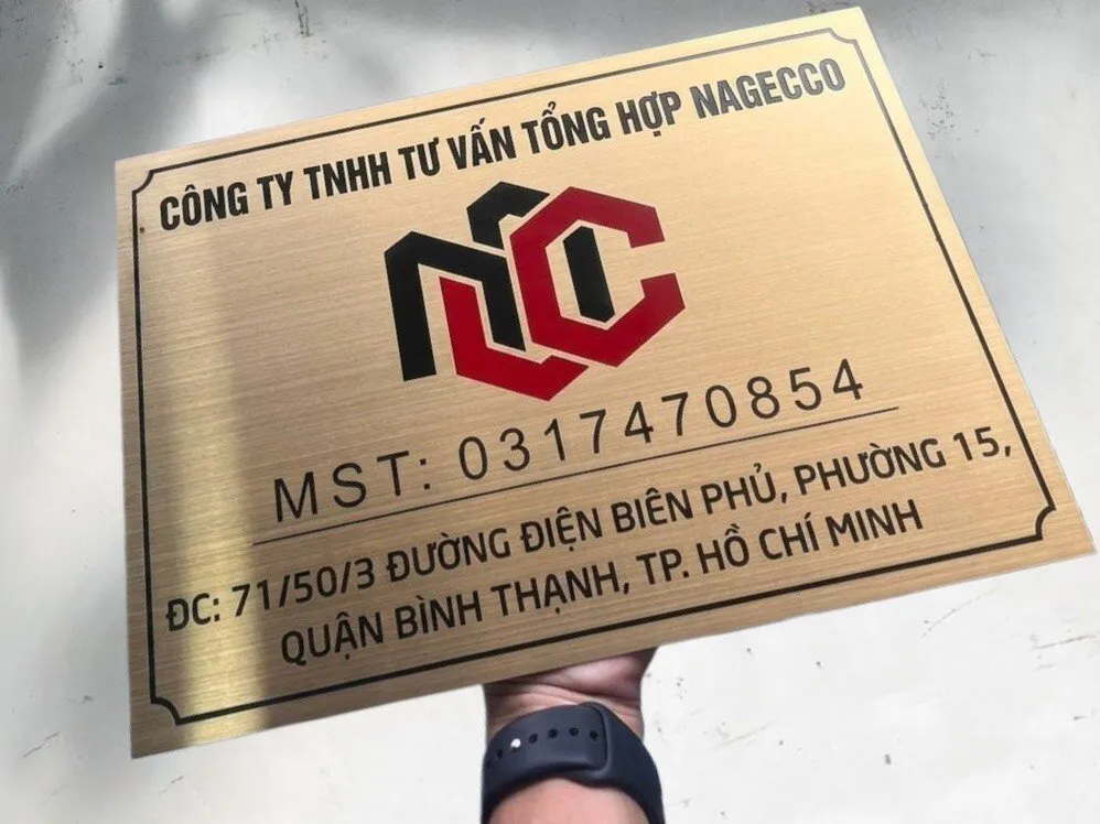 Bảng hiệu công ty inox 304 vàng xước nhìn từ góc nghiêng 45 độ, thể hiện độ dày 15mm và hiệu ứng ánh kim