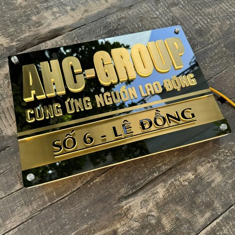 Bảng hiệu công ty inox vàng xước nhìn mặt trước chính diện ban ngày Bảng hiệu công ty inox vàng xước chữ nổi 3D chụp chính diện ban ngày ánh vàng sang trọng