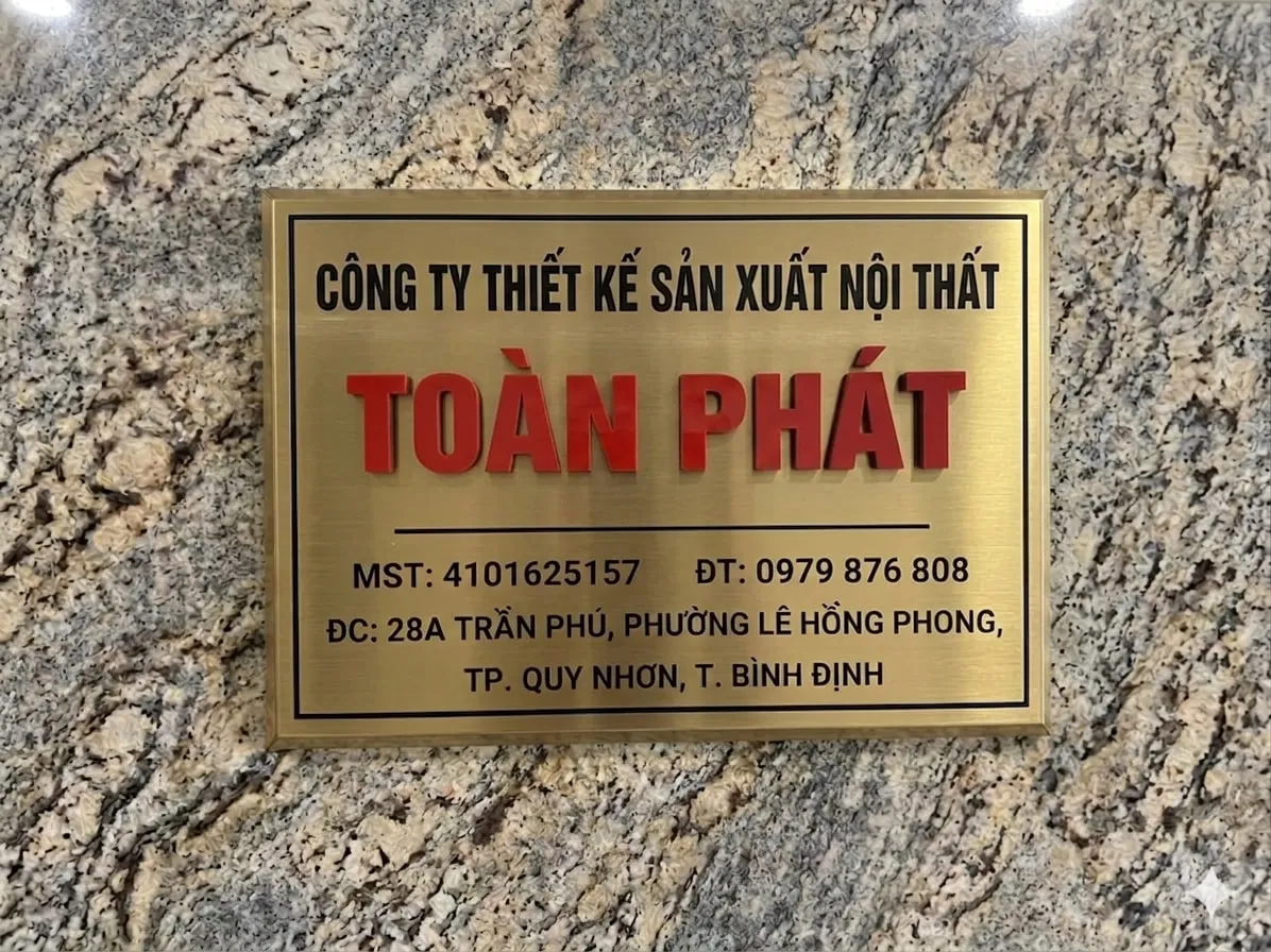 Bảng hiệu công ty inox vàng xước lắp thực tế lên tường đá granite Bảng hiệu công ty chữ nổi 3D inox vàng xước gắn trên tường đá granite tại văn phòng