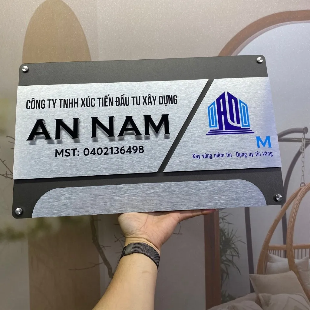 Bảng hiệu công ty inox 3 mảnh module toàn cảnh chụp chính diện trong phòng Bảng hiệu công ty inox xám khói bạc xước 3 mảnh chữ nổi 3D đen logo màu toàn cảnh chính diện cầm tay