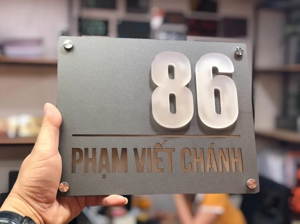 Bảng số nhà mica LED xám titan nhìn mặt trước cầm tay – phông xưởng Bảng Hiệu Vàng Bảng số nhà 3D mica hút LED nền xám titan mặt trước cầm tay chụp trong xưởng sản xuất Bảng Hiệu Vàng