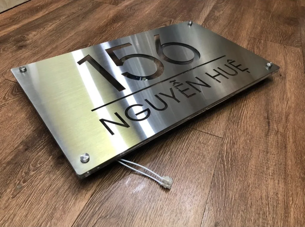 Bảng số nhà inox 304 hairline — góc nghiêng 45 độ thấy rõ độ dày và vân kim loại Bảng số nhà inox 304 hairline chụp góc nghiêng 45 độ, thấy rõ cạnh vuông và vân chải bề mặt