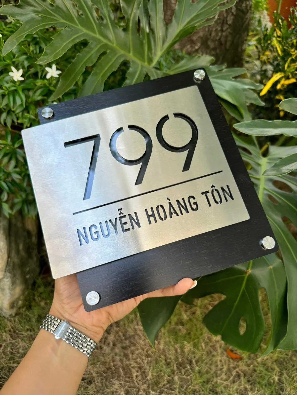 Bảng số nhà inox cắt CNC xuyên thấu — mẫu số 799 Nguyễn Hoàng Tôn Bảng số nhà inox bạc xước cắt CNC xuyên thấu số 799 đường Nguyễn Hoàng Tôn cầm trên tay mặt trước