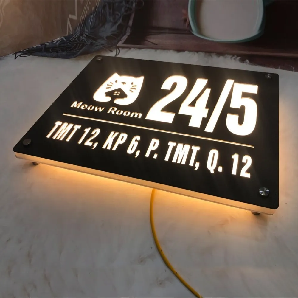 Bảng số nhà inox LED backlit vàng ấm — góc nghiêng cao thấy toàn bộ hiệu ứng sáng Bảng số nhà inox đen mờ cắt xuyên thấu LED vàng ấm góc cao nhìn xuống