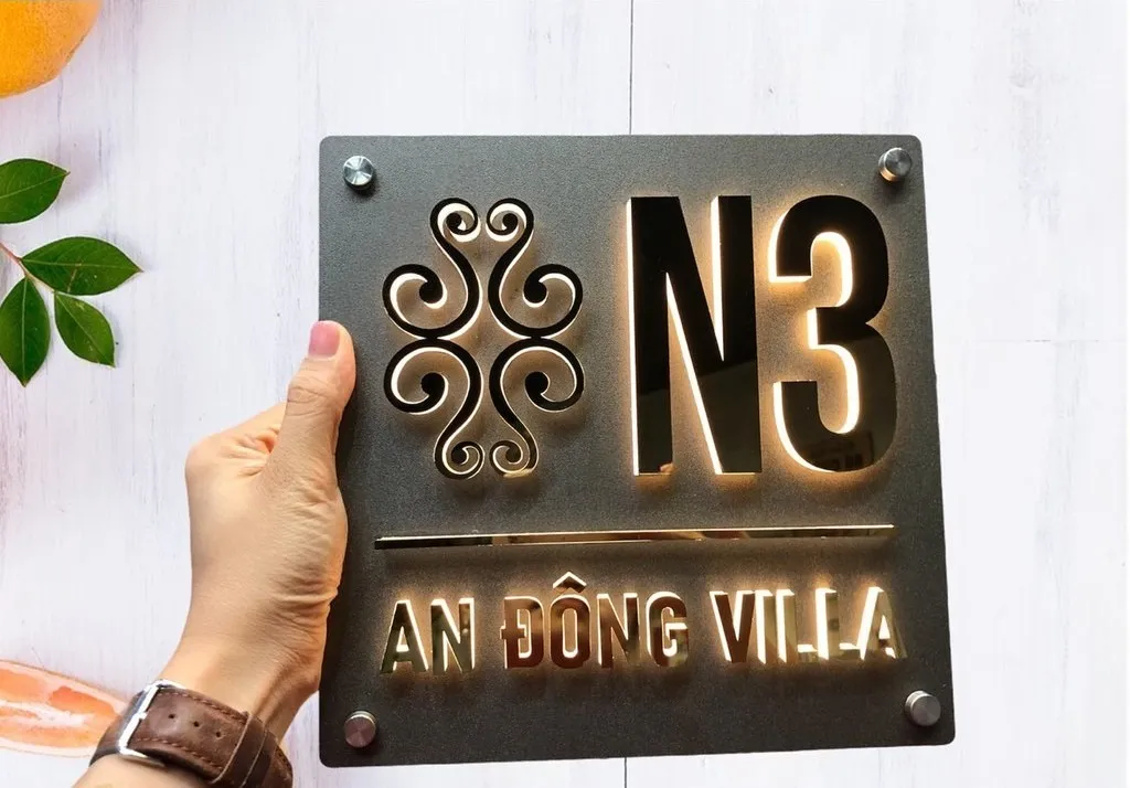 Bảng số nhà inox sơn tĩnh điện đen cầm trên tay — phối cảnh thực tế Cầm trên tay bảng số nhà inox 3D chữ gương để thấy kích thước thực tế