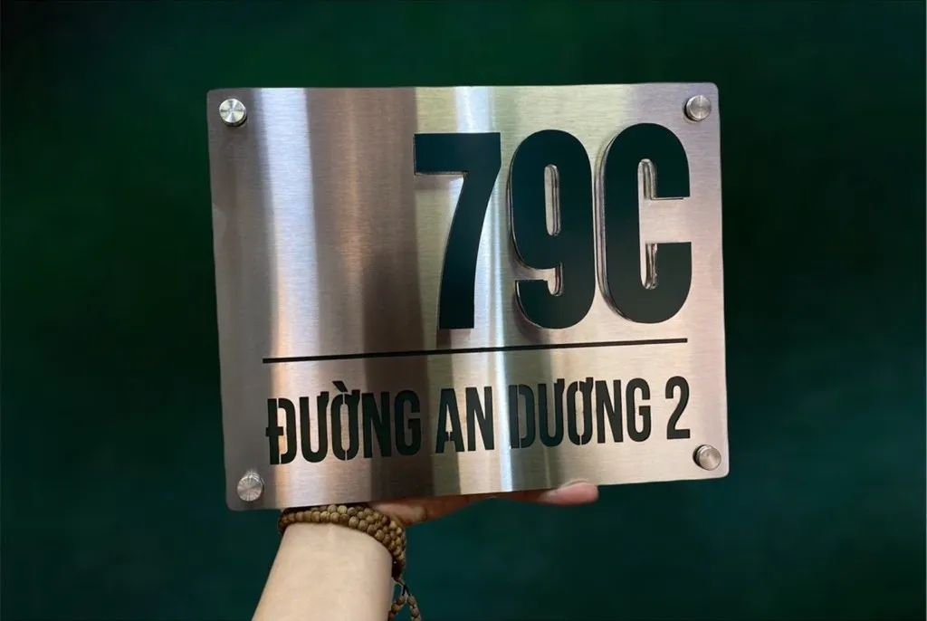 Bảng số nhà inox xước bạc chữ đen nổi 3D chụp trên nền xanh – nổi bật, dễ đọc từ xa Bảng số nhà inox xước bạc chữ số đen nổi 3D đặt trên nền xanh lá – màu bạc xước nổi bật tương phản với nền tối