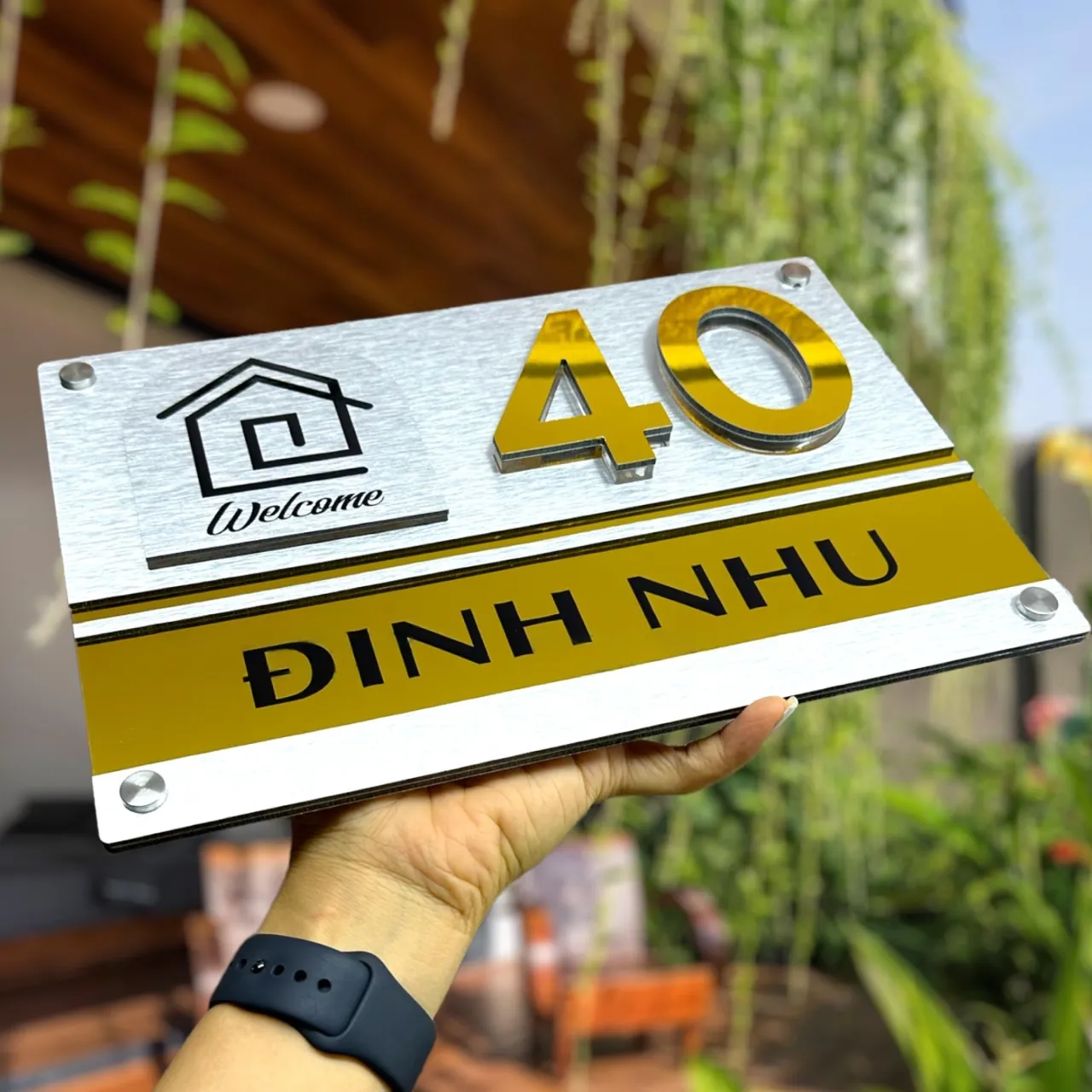 Sản phẩm bảng số nhà inox hoàn thiện thực tế – Bảng Hiệu Vàng Bảng số nhà inox 304 vàng gương hoàn thiện thực tế, cầm tay thể hiện kích thước và chất lượng gia công