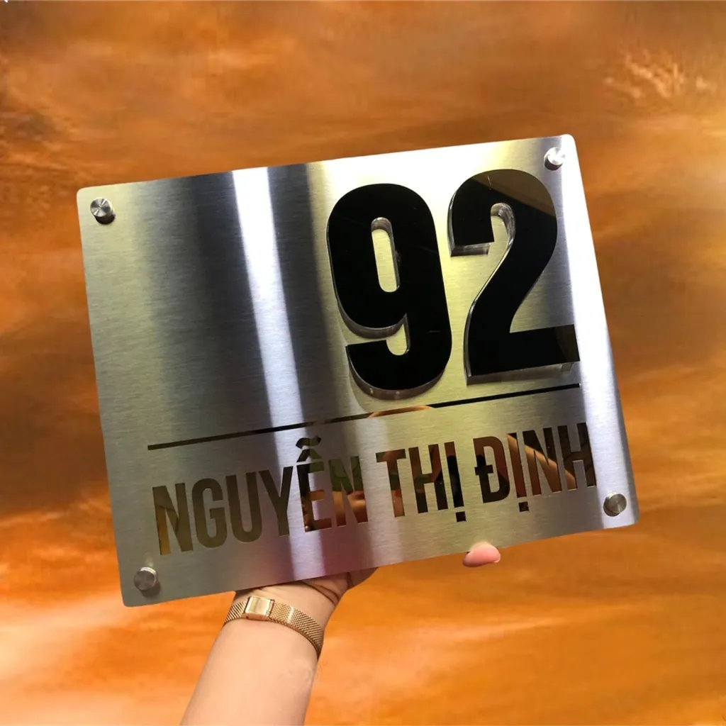 Bảng số nhà inox siêu mỏng 5mm chụp góc chếch – thấy rõ độ mỏng tinh tế và chữ nổi 3D cao 10mm Bảng số nhà inox xước bạc vàng gương siêu mỏng 5mm chụp góc chếch thể hiện rõ độ mỏng thân bảng và chiều cao chữ nổi 3D