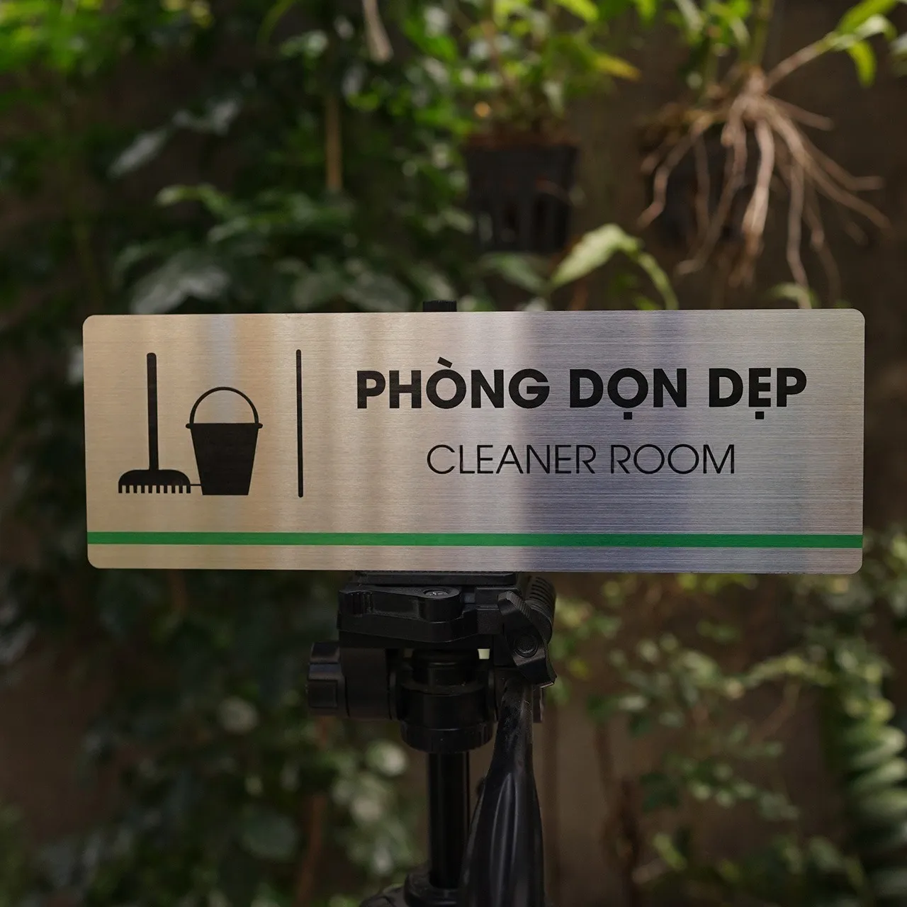 Phối cảnh thực tế bảng tên phòng dọn dẹp inox 304 brushed đặt trên tripod ngoài trời