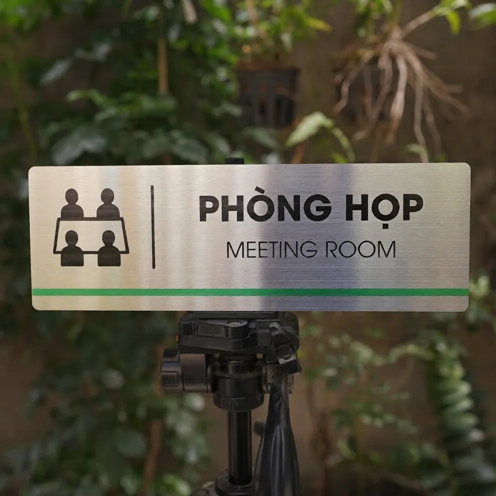 Bảng Tên Phòng Họp Inox 304 – Mặt Trước Thẳng Thấy Rõ Pictogram Và Sọc Xanh Lá Bảng tên phòng họp inox 304 trên giá đỡ mặt trước thẳng thấy rõ pictogram bàn họp và sọc xanh lá