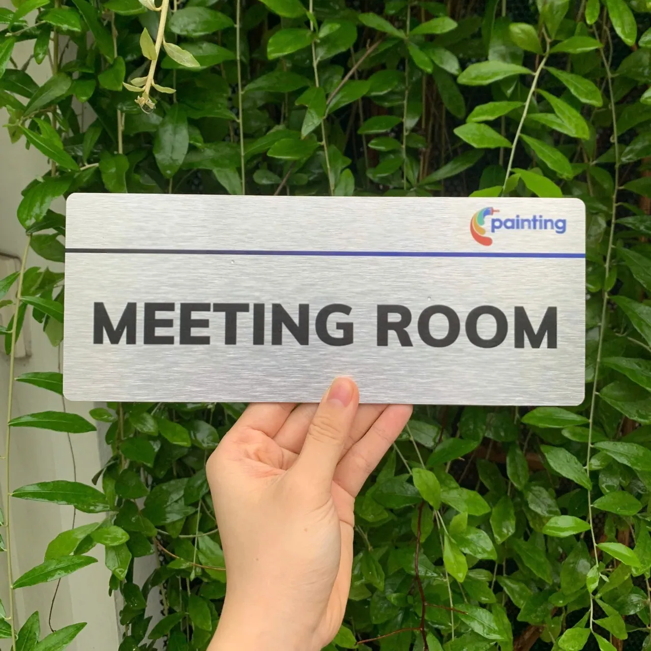 Bảng tên Phòng Họp - Meeting Room inox in UV logo màu Bảng tên phòng họp Meeting Room inox in UV logo màu trên nền cây xanh