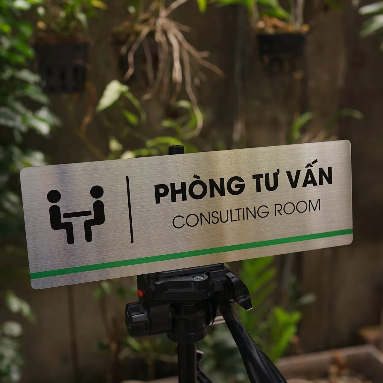 Bảng tên phòng tư vấn inox 304 nhìn góc thấp thấy rõ sọc xanh lá trang trí phía dưới