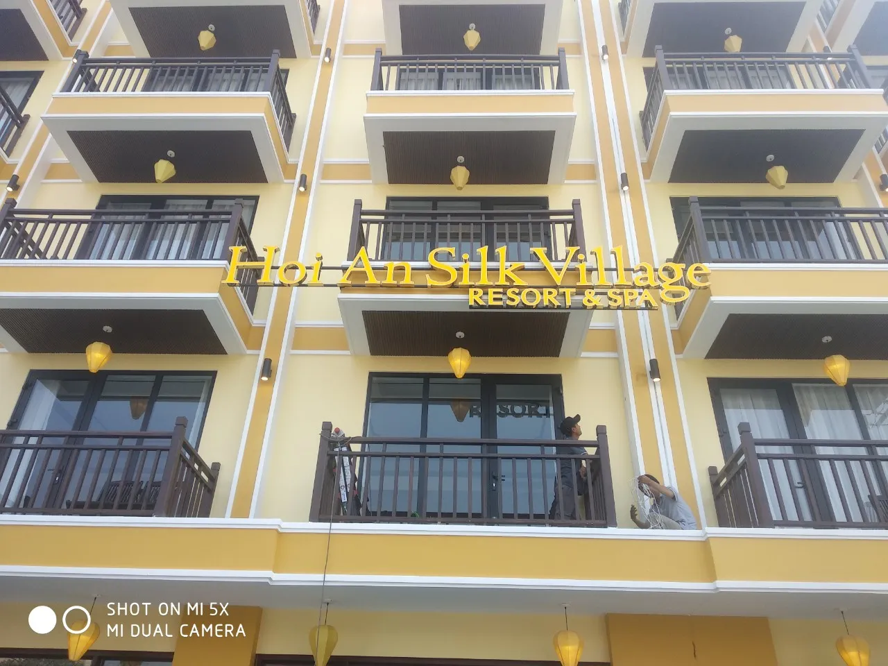 Bảng hiệu resort Hoi An chữ vàng trên mặt tiền tòa nhà cao tầng ban ngày
