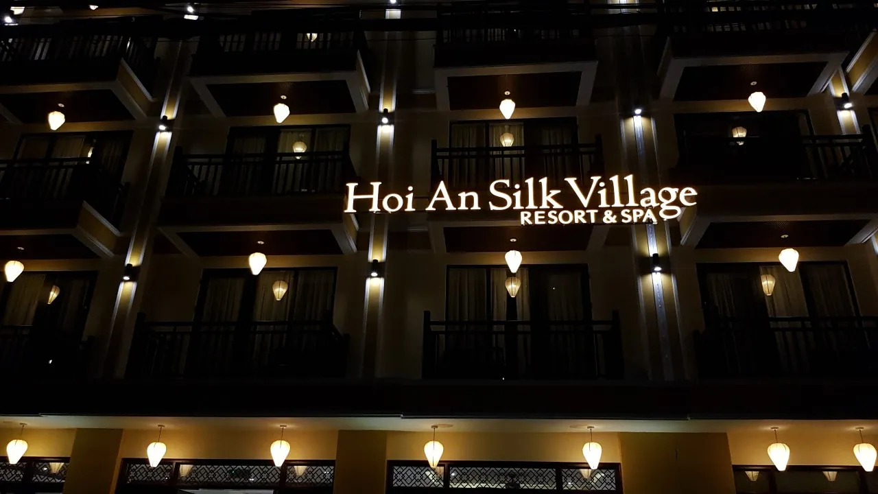 Bảng hiệu Hoi An Silk Village chữ vàng lắp mặt tiền tòa nhà cao tầng với đèn LED halo