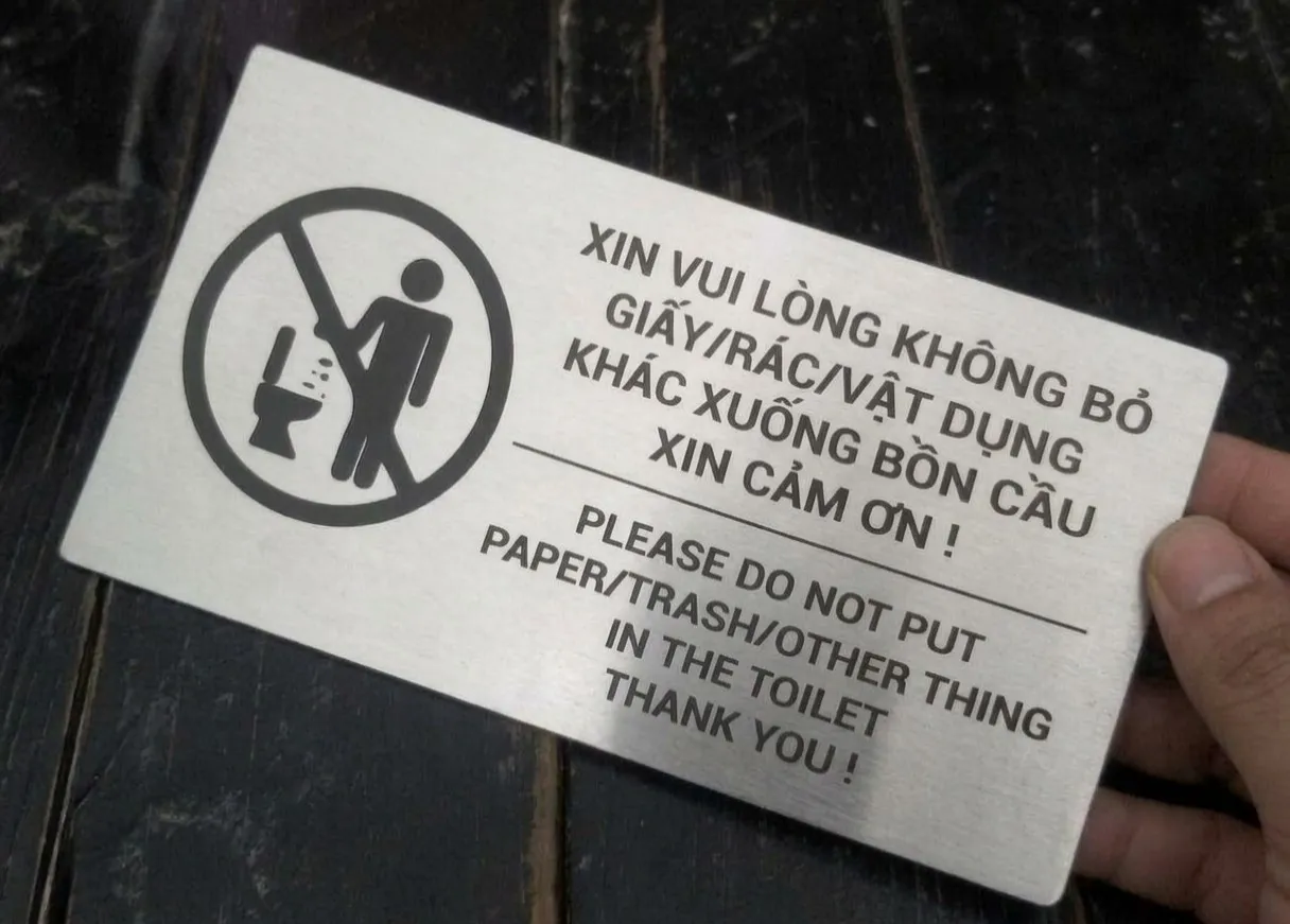 Bảng nội quy toilet góc nghiêng cầm tay nền tối
