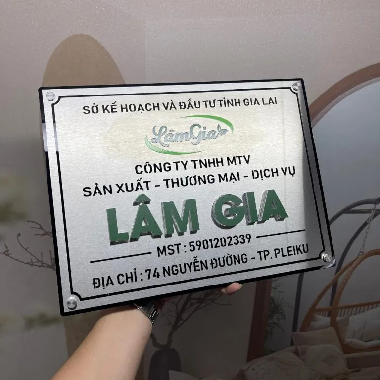 Mặt trước bảng hiệu công ty inox bạc xước, chữ nổi 3D LÂM GIA màu xanh lá cao 1cm, logo thương hiệu, khung viền chìm
