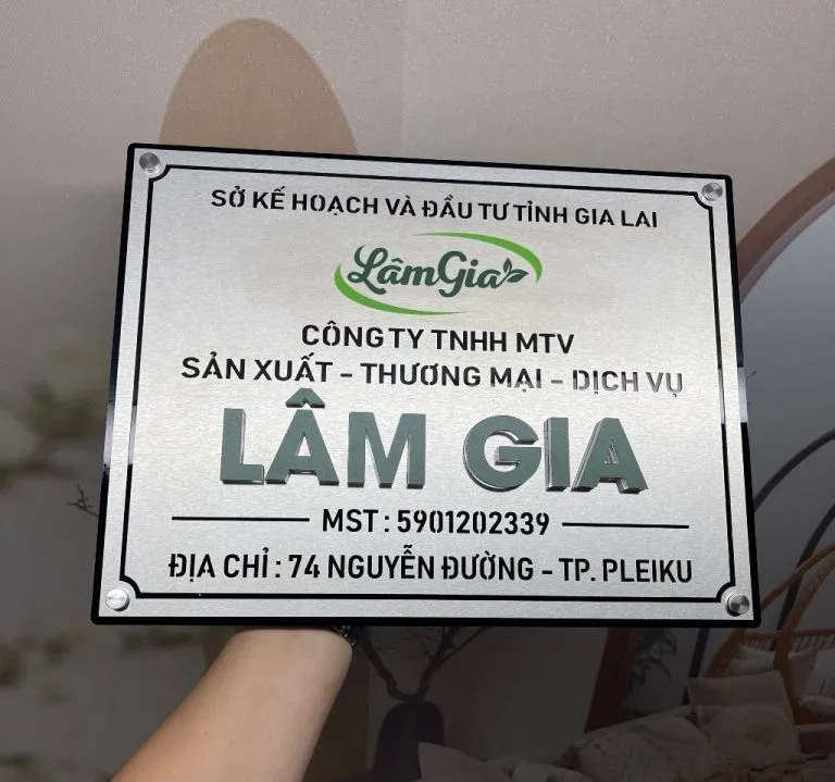 Toàn cảnh bảng hiệu công ty inox bạc xước nền dày 15mm, chữ nổi 3D màu xanh lá tùy chỉnh, khung viền chìm, logo công ty
