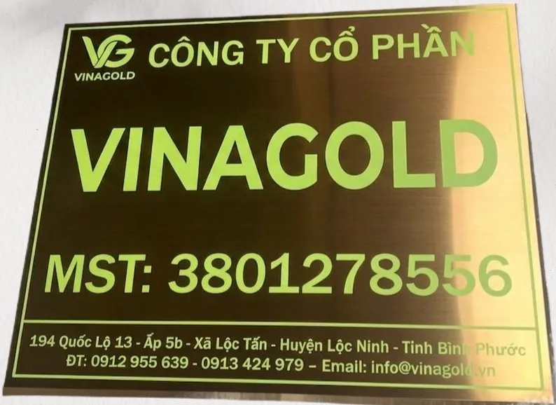 Cận cảnh chữ in UV xanh lá trên bảng hiệu inox vàng đồng – Bảng Hiệu Vàng cận cảnh chữ in UV màu xanh lá sắc nét trên nền inox vàng đồng xước