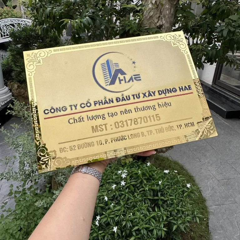 cận cảnh logo màu thương hiệu và chữ khắc CNC sơn tĩnh điện sắc nét trên bảng hiệu công ty inox vàng gương