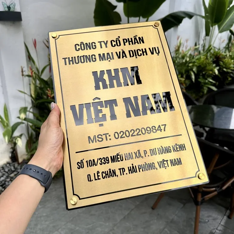 cận cảnh chữ khắc ăn mòn kim loại sơn tĩnh điện đen sắc nét trên bảng hiệu inox vàng xước