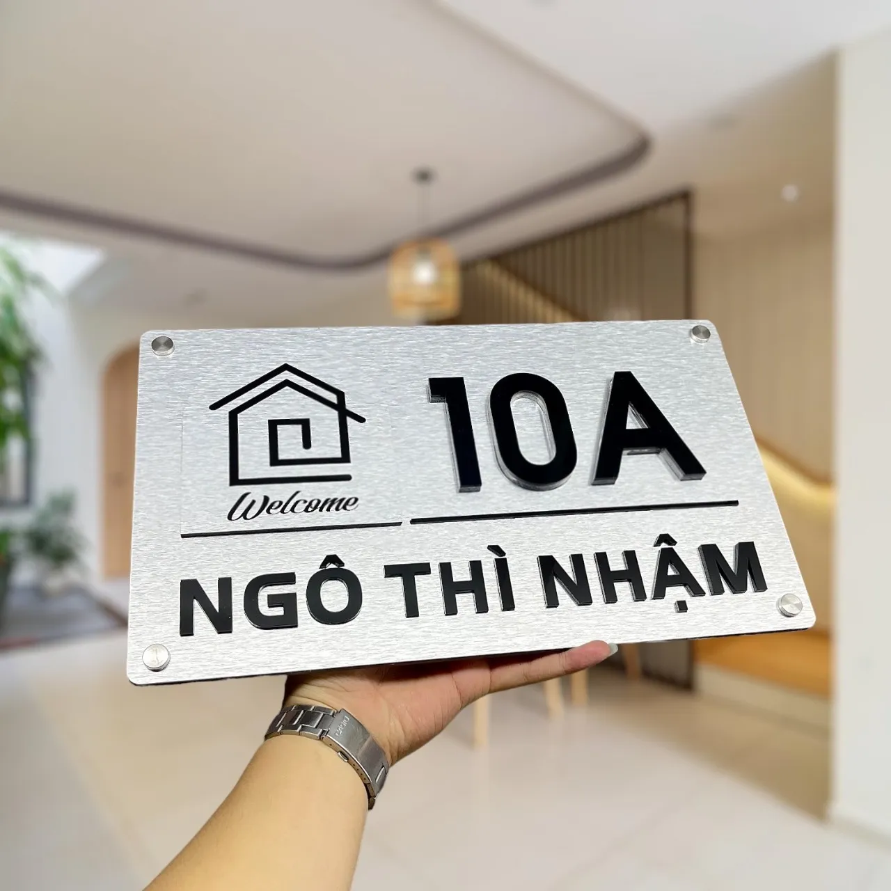 Bảng số nhà inox bạc xước icon ngôi nhà Welcome số 10A cầm tay nhìn góc nghiêng khác