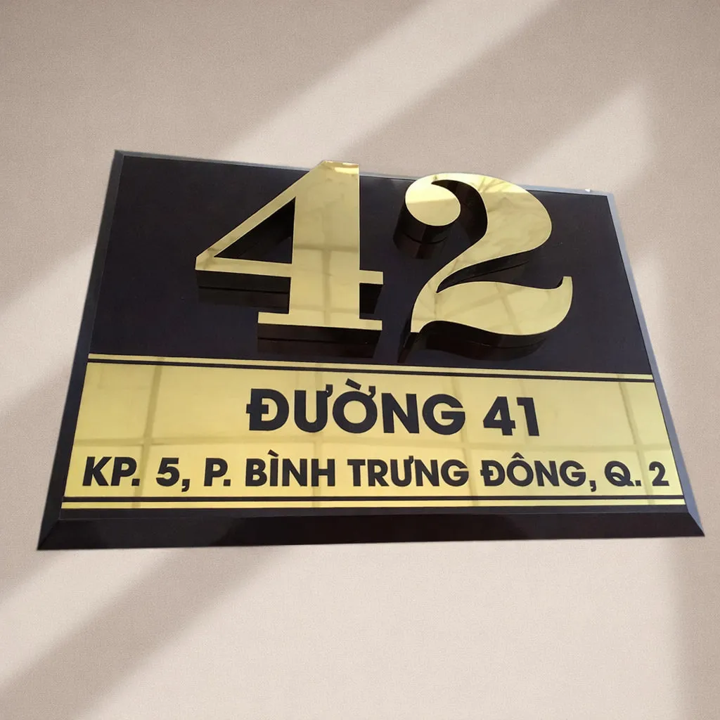 Bảng số nhà nền đen chữ vàng – góc nghiêng ngang thấy dải địa chỉ và cạnh vát vàng Bảng số nhà nền đen chữ vàng nổi 3D – góc nghiêng ngang thấy rõ dải địa chỉ vàng và cạnh vát chéo