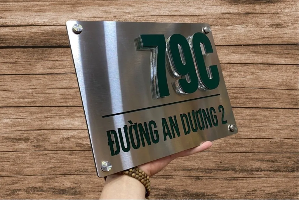 Bảng số nhà inox xước bạc tối giản chụp góc rộng – kích thước thực tế và độ hoàn thiện bề mặt Bảng số nhà inox xước bạc chữ nổi sơn xanh lá chụp góc rộng thể hiện kích thước thực tế và chất lượng hoàn thiện toàn bộ sản phẩm