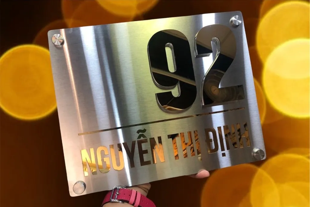 Bảng số nhà inox xước bạc chữ nổi vàng gương – chụp nghệ thuật bokeh ánh sáng vàng lung linh Bảng số nhà inox xước bạc chữ số vàng gương nổi 3D chụp nghệ thuật với bokeh ánh sáng vàng lung linh phía sau