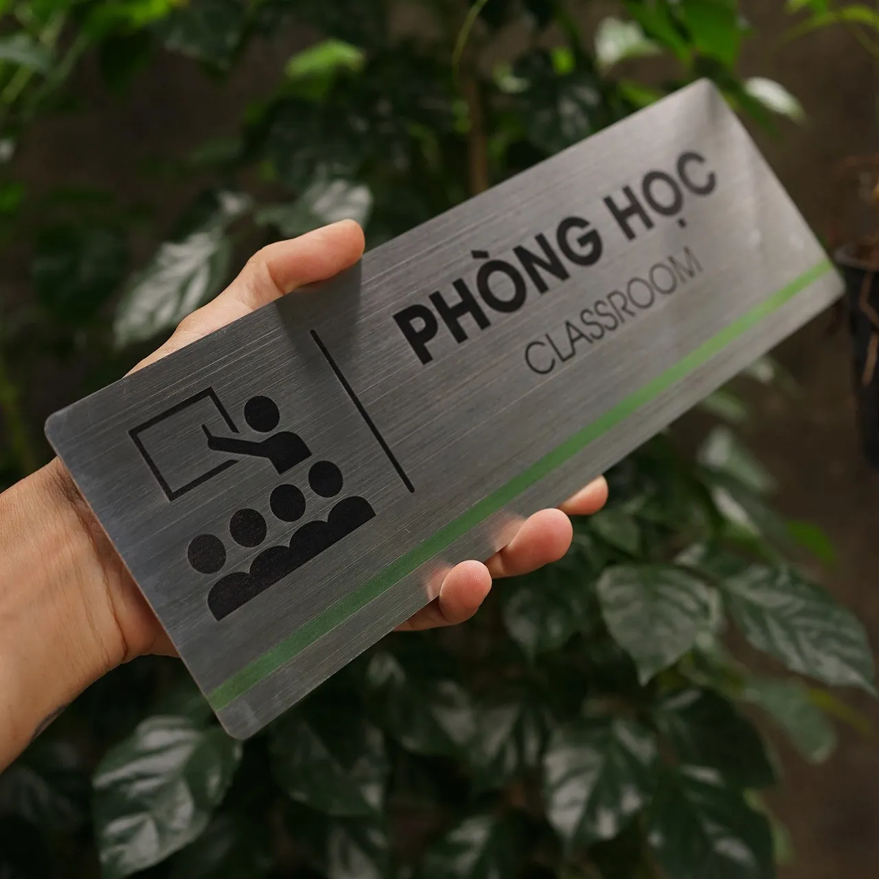 Bảng tên phòng học inox 304 cầm tay nghiêng phải thấy rõ vân xước và sọc màu xanh lá