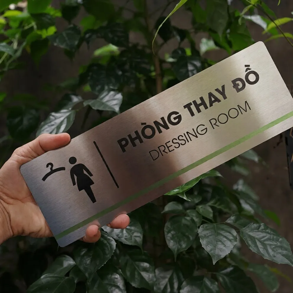 Bảng tên phòng thay đồ inox 304 cầm tay góc nghiêng phải thấy rõ hiệu ứng vân phay xước ánh bạc tinh tế