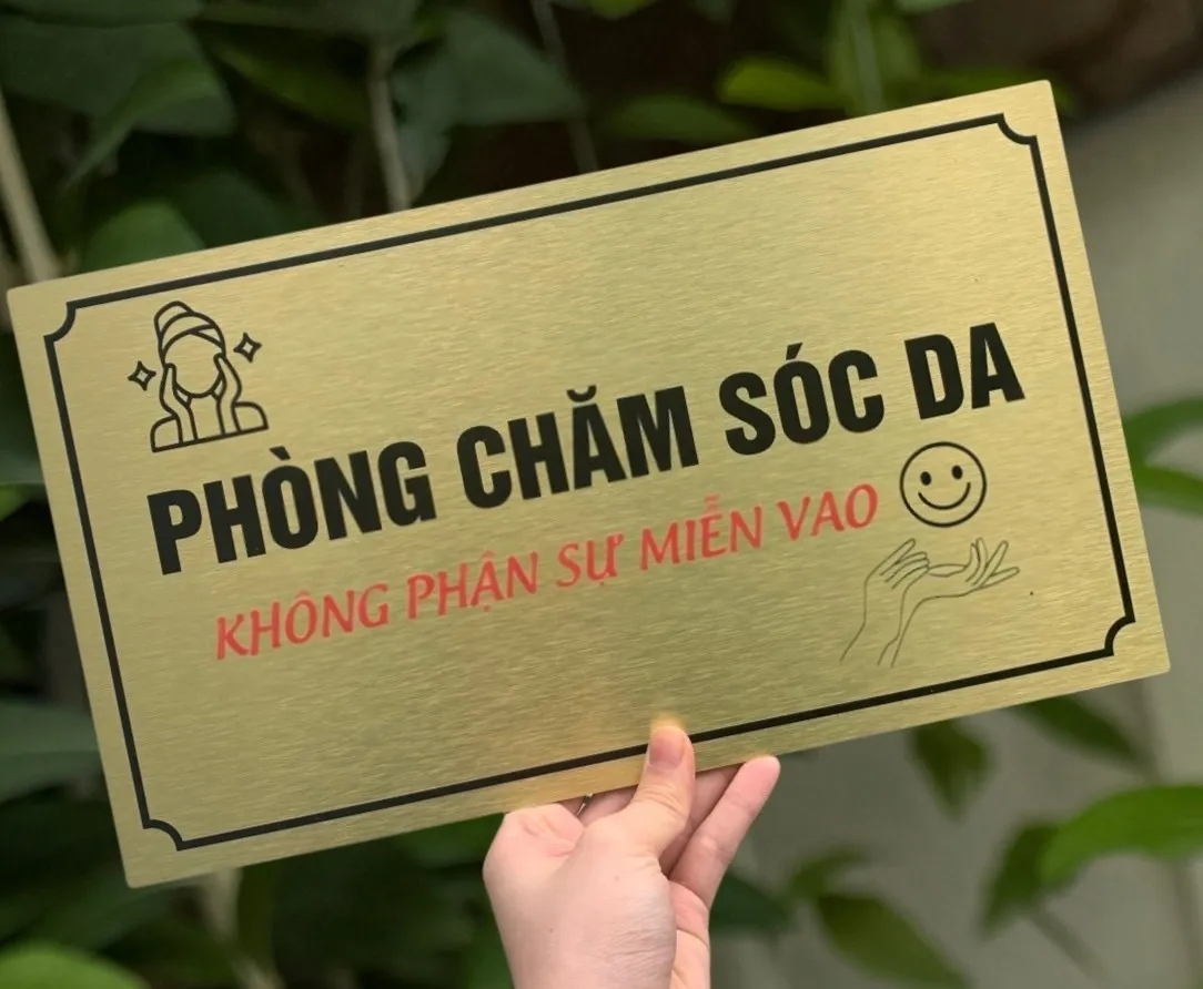 Góc nghiêng bảng tên phòng chăm sóc da inox vàng xước