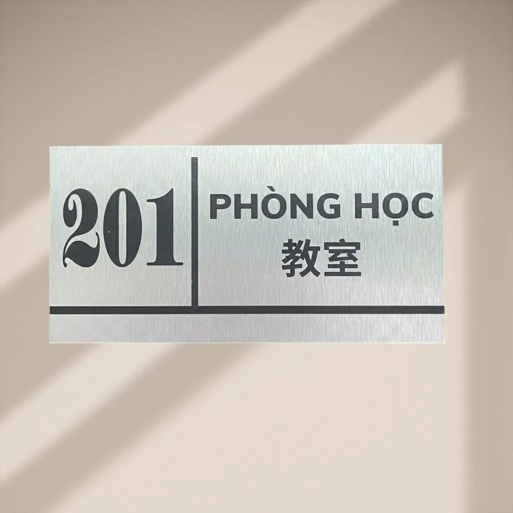 Cận cảnh bảng tên phòng học inox bạc xước in UV chữ đen