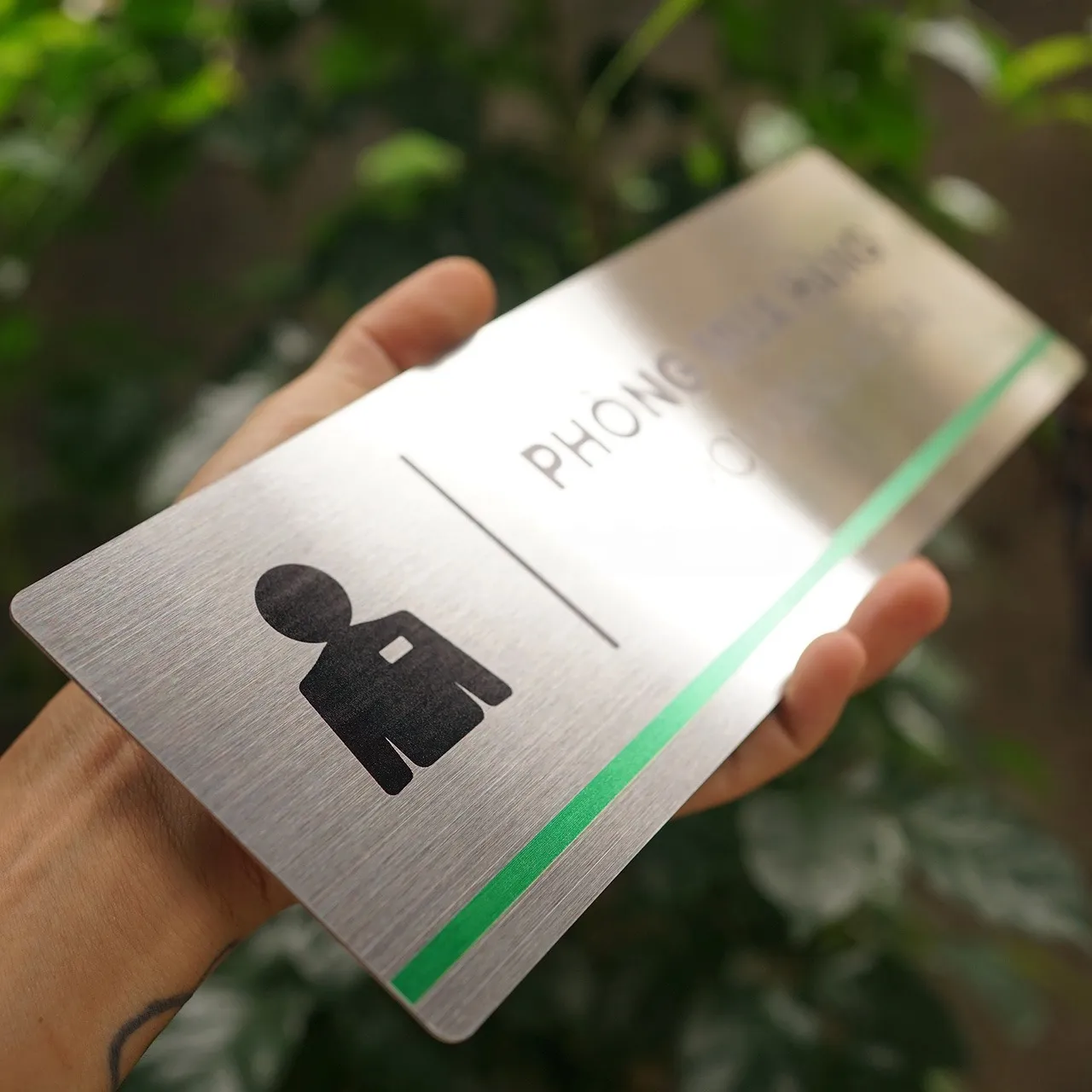 Cận Pictogram và Sọc Xanh – Bảng Tên Phòng Mua Hàng Inox 304 Phay Xước Cận cảnh pictogram nhân vật và sọc xanh lá bảng tên phòng mua hàng inox 304 phay xước