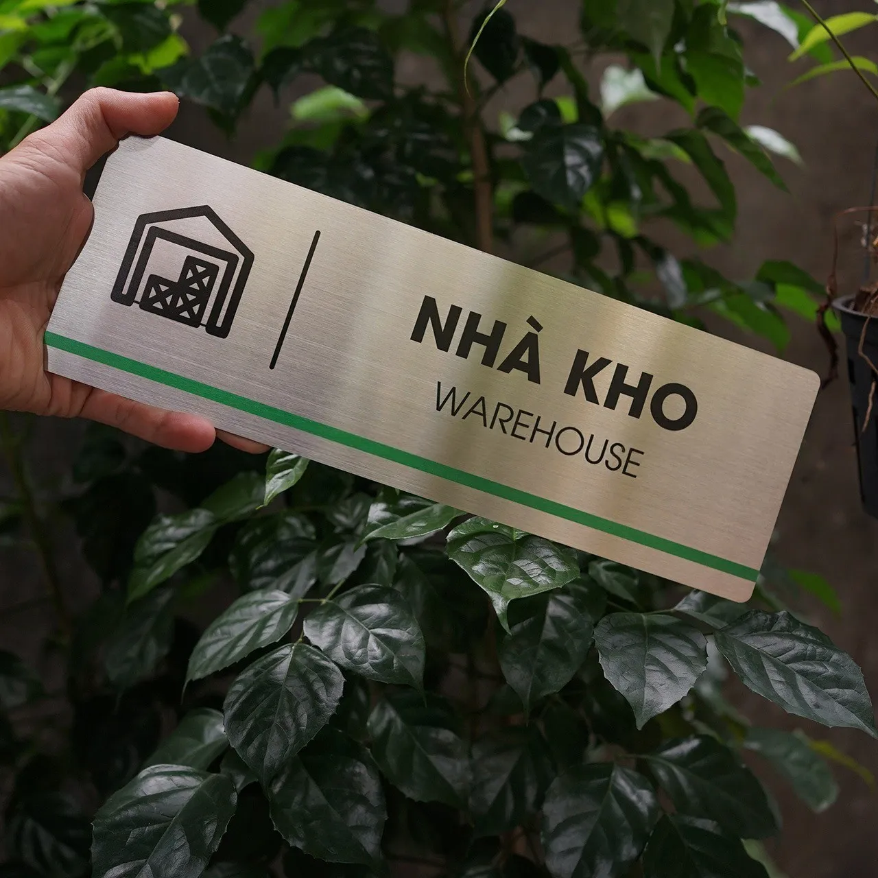 Bảng tên nhà kho inox 304 cầm tay góc nghiêng phải thấy rõ pictogram kho hàng với cửa kéo chi tiết