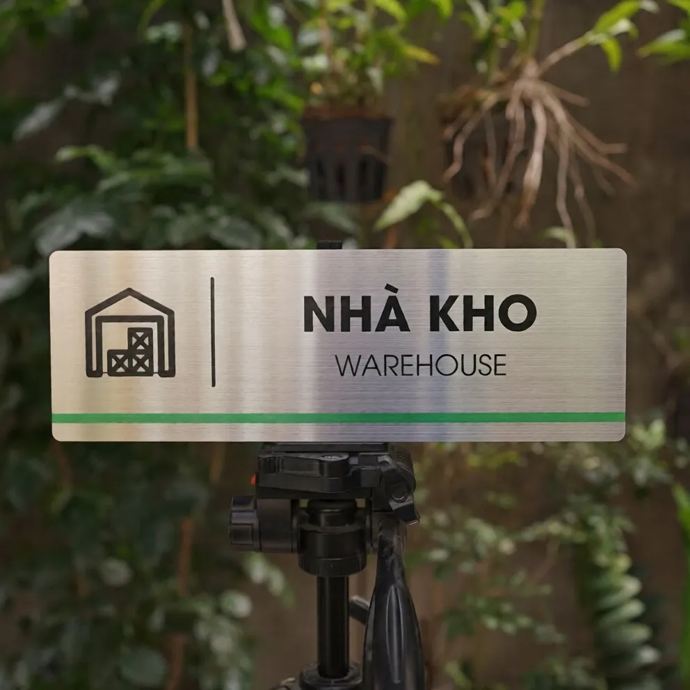Bảng tên nhà kho inox 304 trên giá đỡ mặt trước thẳng thấy rõ pictogram kho hàng và sọc xanh lá