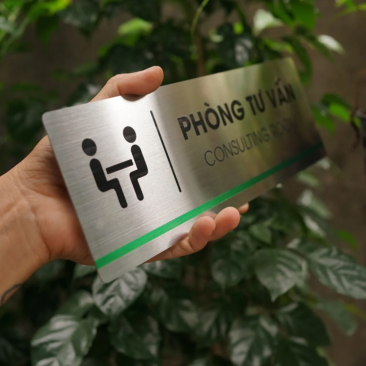 Cận cảnh pictogram hai nhân vật tư vấn in UV đen sắc nét trên nền inox 304 phay xước