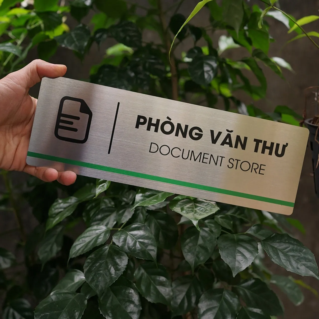 Bảng tên phòng văn thư inox 304 – mặt trước chính diện nổi bật trên nền xanh tự nhiên Bảng tên phòng văn thư inox 304 brushed nhìn thẳng mặt trước, nền cây xanh tự nhiên