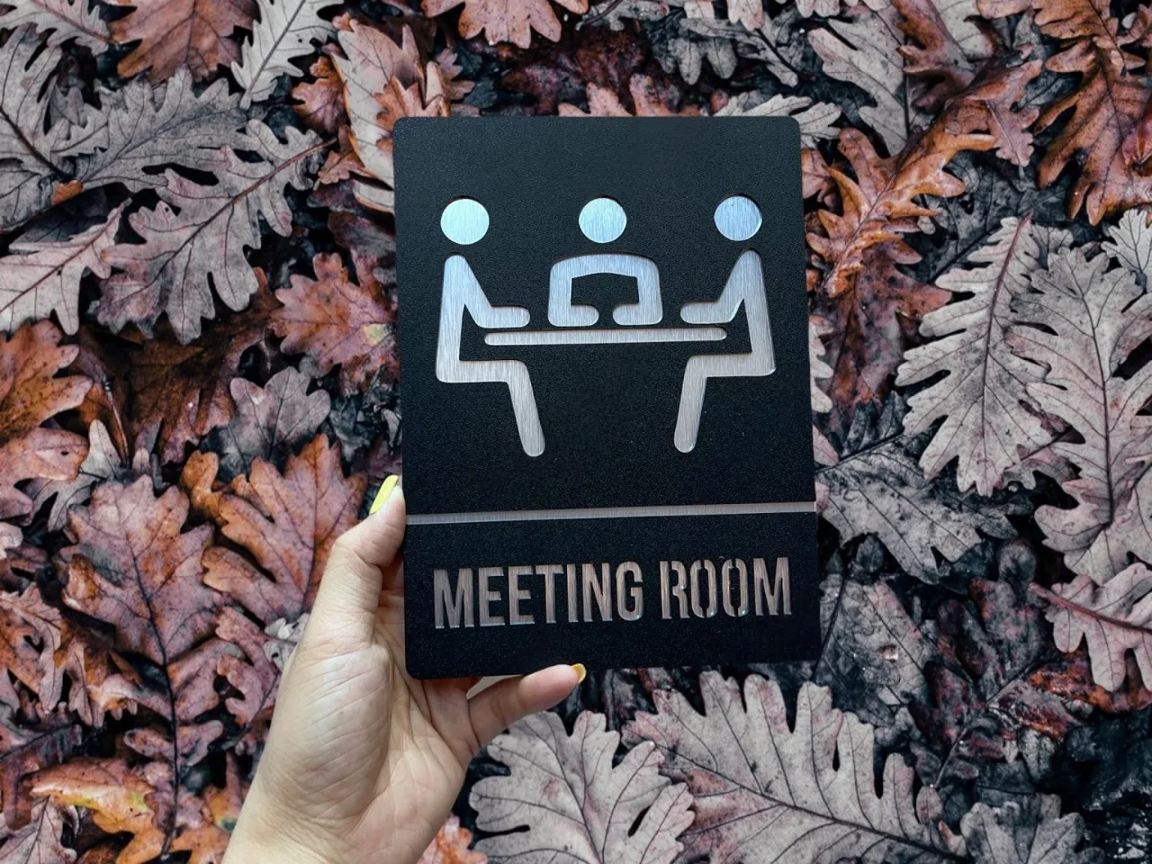 Cận cảnh chữ meeting room nhôm xước âm bản trên nền inox đen sần